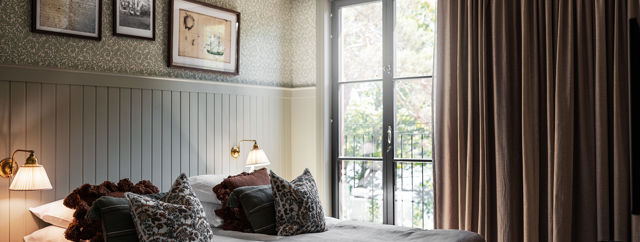 Vackert hotellrum i sobra färger och stora fönster